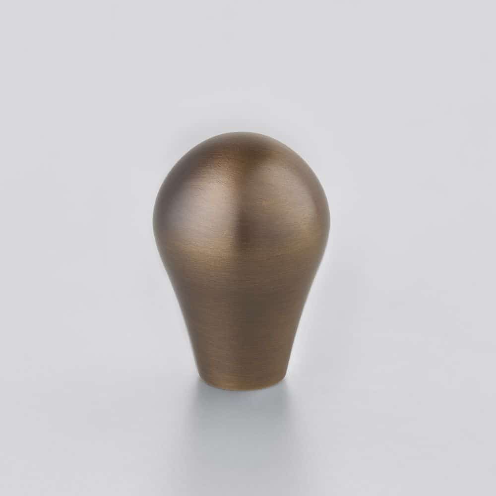 ZEB Horton Brasses Bronze colored teardrop shaped metal knob standing upright on a white surface
