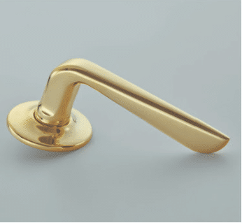 Gold brass door lever on a round plate close up