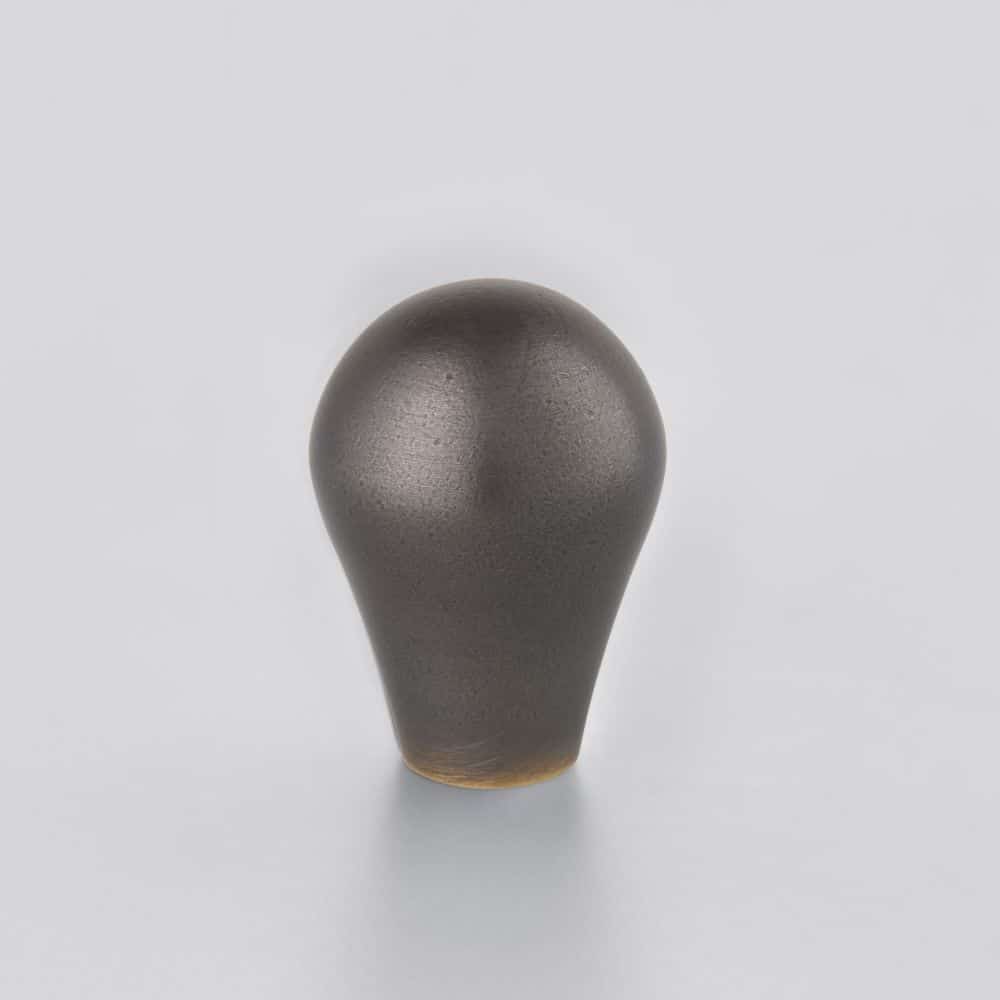 distressedcarbon Horton Brasses Dark gray teardrop shaped knob standing upright on a pale surface with a smooth matte finish