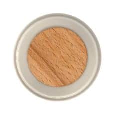 Round makeup pan containing peach toned eyeshadow with a light beige case