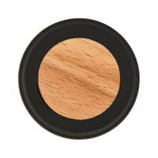 Round makeup compact with peach toned pressed powder inside a black case