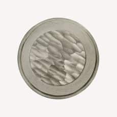 Close up of a round metal button with a textured wavy center