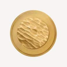 Round gold button with a textured honeycomb pattern in the center viewed from above