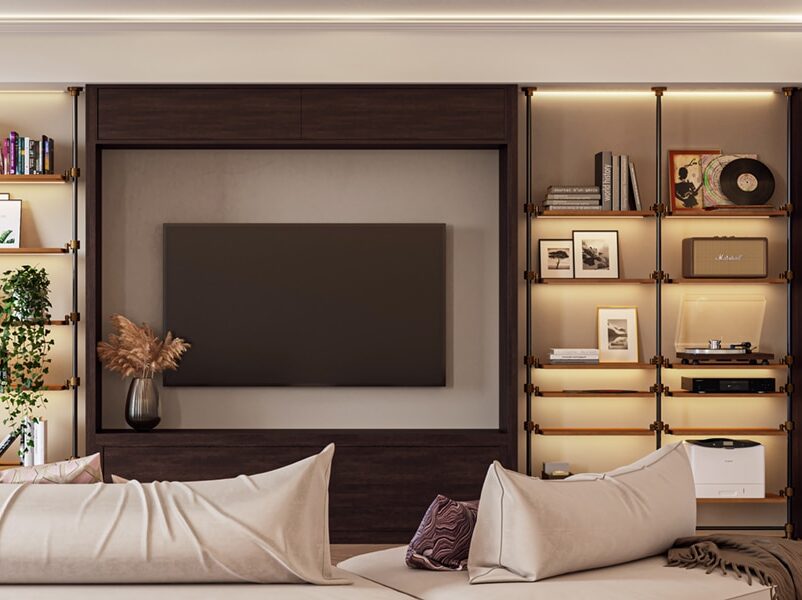 Cozy living room with a dark wood media wall, wall-mounted TV, and lit open bookshelves on both sides.