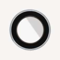 Close up of a black circular ring with a light gray outer rim on a pale background